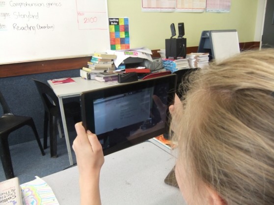 Student using iPad to read the whiteboard